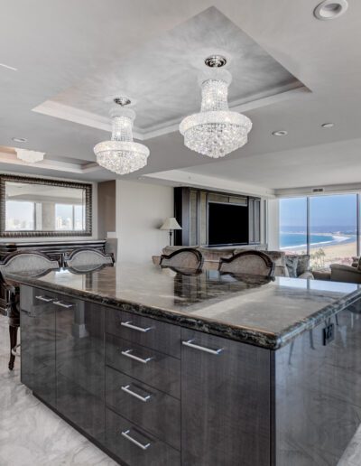 A large kitchen with marble counter tops and a view of the ocean.