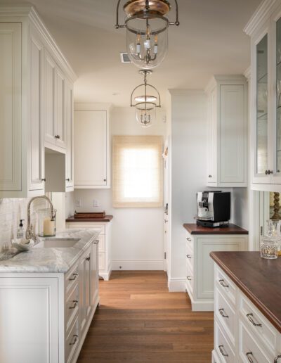 A kitchen with white cabinets and a wine cooler.