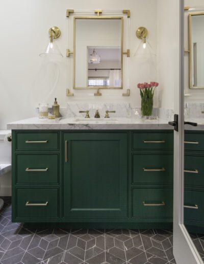 A bathroom with green cabinets and a marble floor.